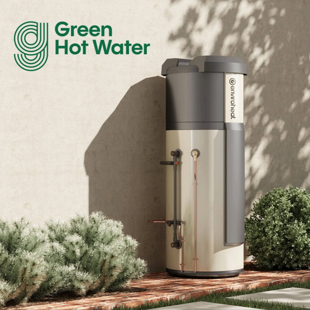 A Green Hot Water heat pump unit installed beside a home